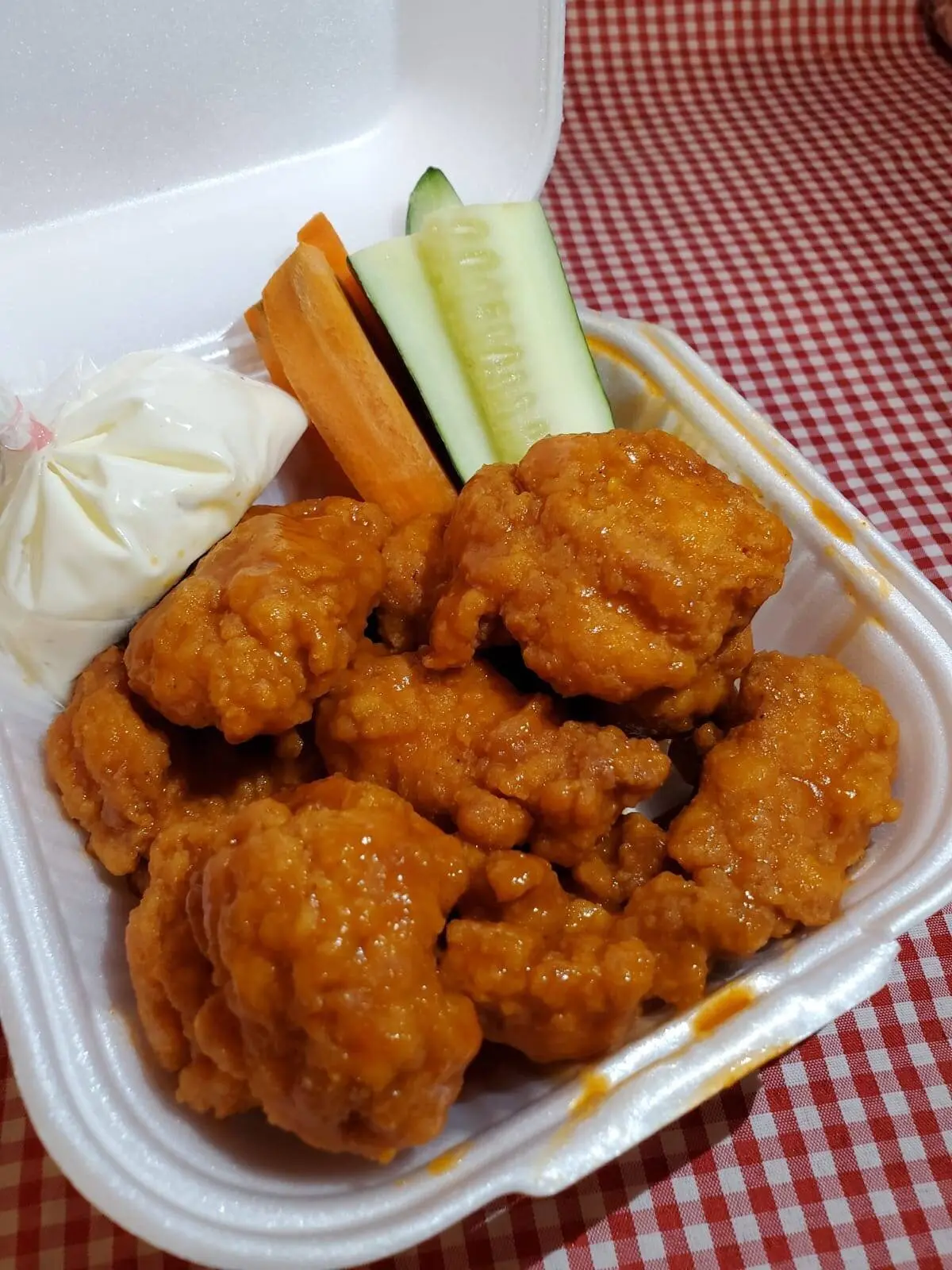 Boneless de Pollo en salsa Búfalo con vegetales y aderezo Ranch.