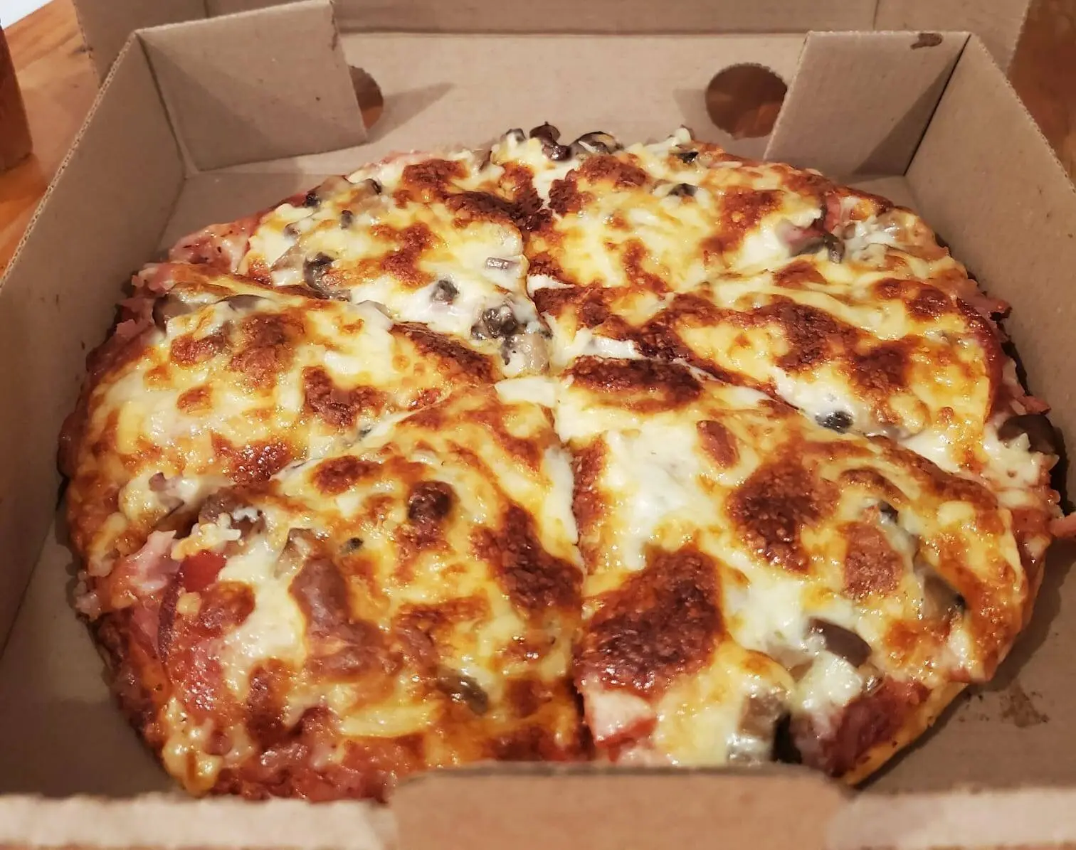 Pizza Calixto con jamón, piña y champiñones.