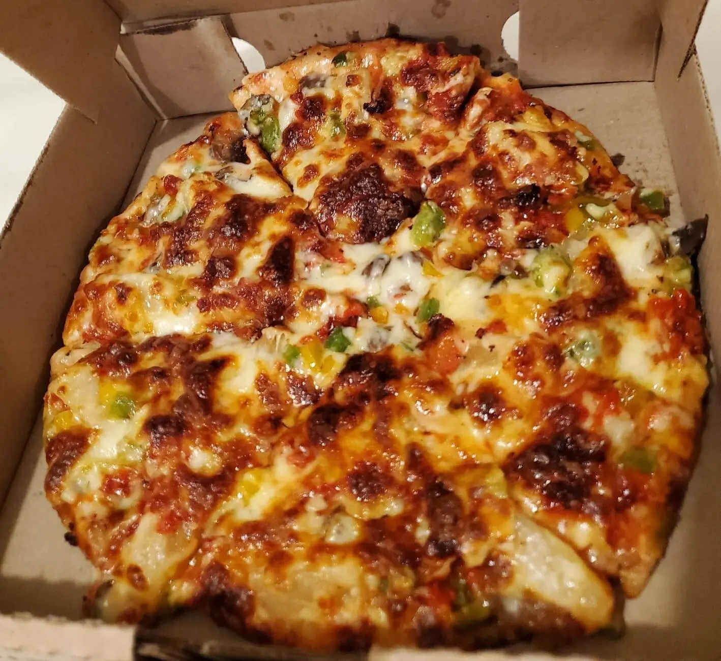 Pizza Colibrí con pepperoni, piña, champiñones, tocino y pimiento morrón.